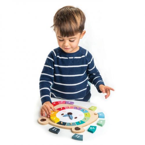boy playing with wooden bear shaped clock