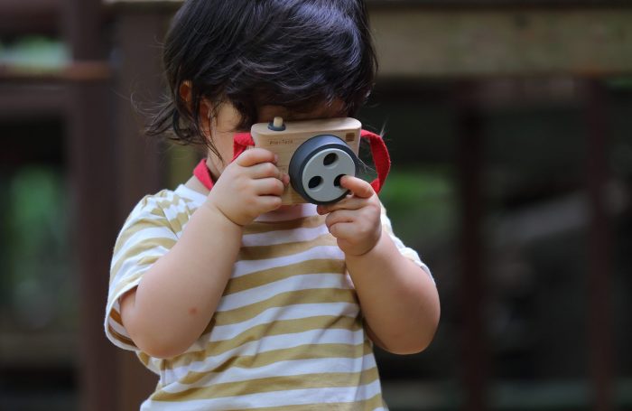 kid taking a photo with toy camera with three colored lenses