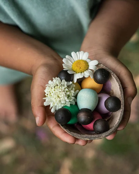 Grapat Houten Baby Nins Poppetjes Donker in Kokosnoot in de hand van een kind