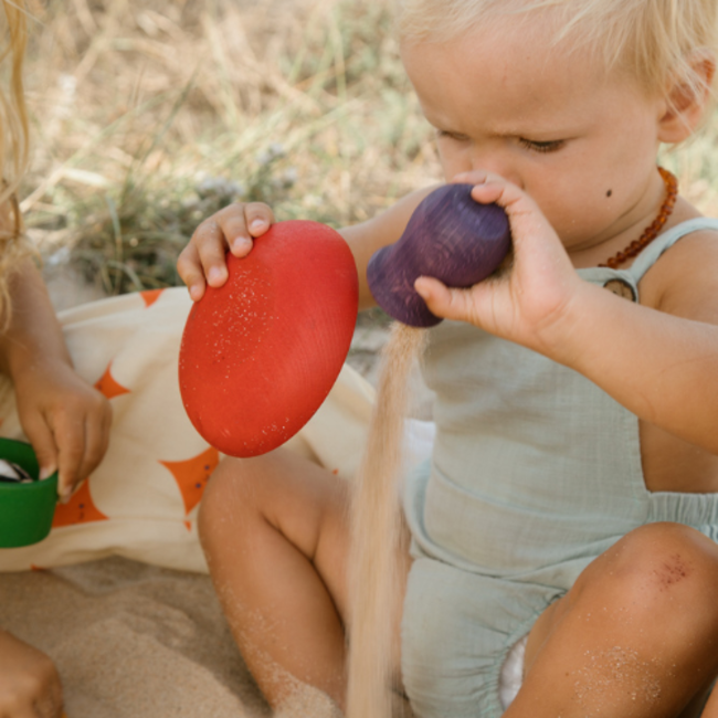 A kid playing with Grapat Houten Potjes